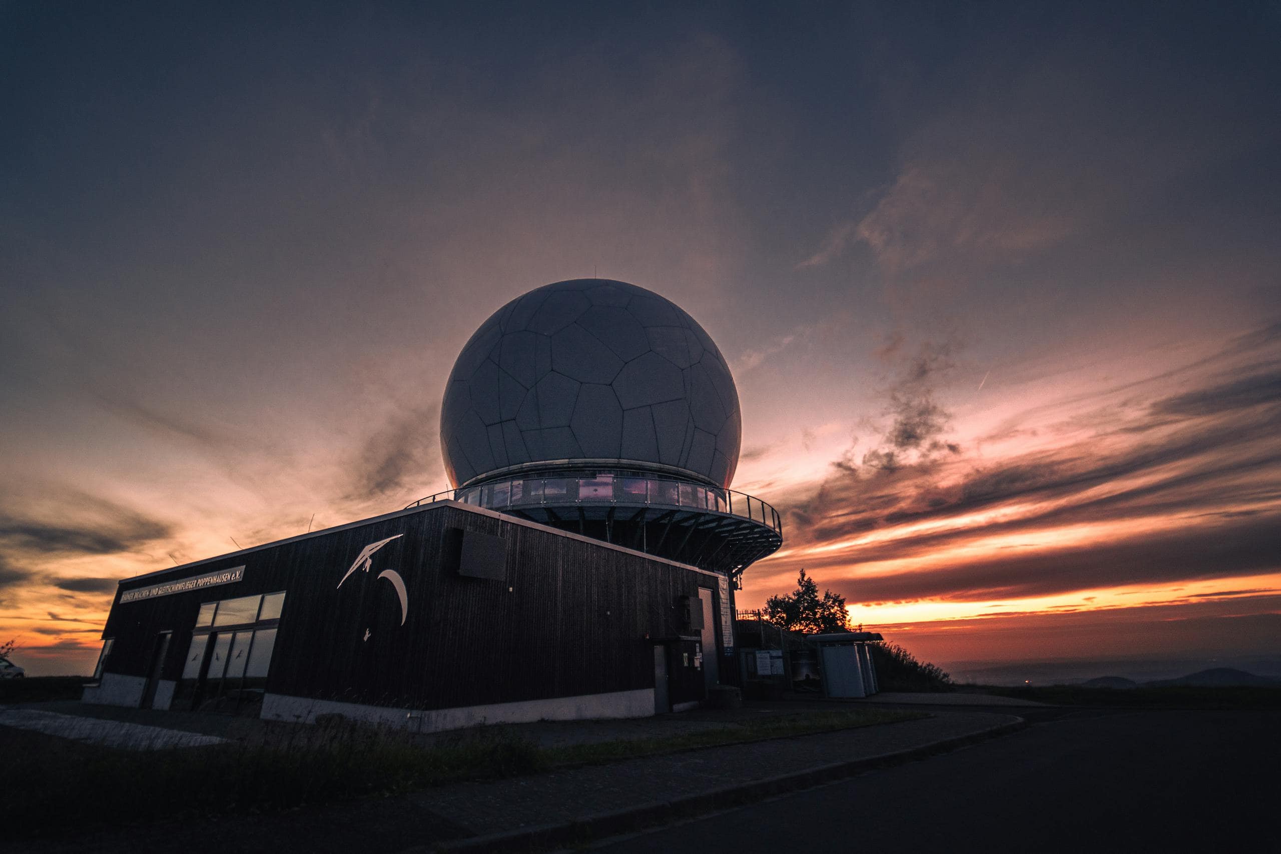 A radar dome at Wasserkuppe, Germany silhouetted against a stunning sunset sky.